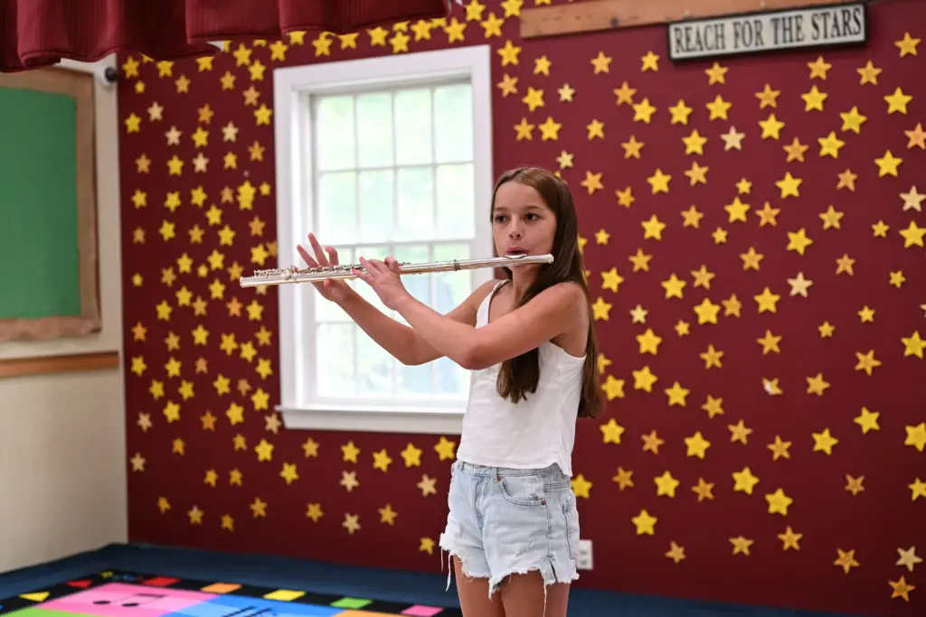 A girl playing the flute on the stage at Lifelong Music School in Hunterdon County, NJ